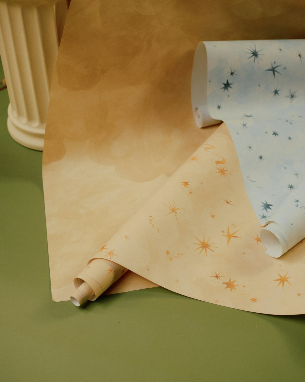 Two overlapping rolls of Luminaries wall coverings