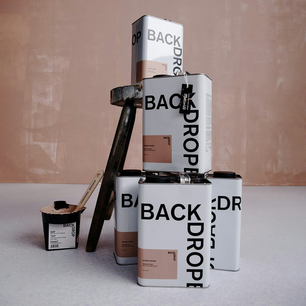 A stack of STUDIO HOURS paint cans from the Backdrop x Madewell collection