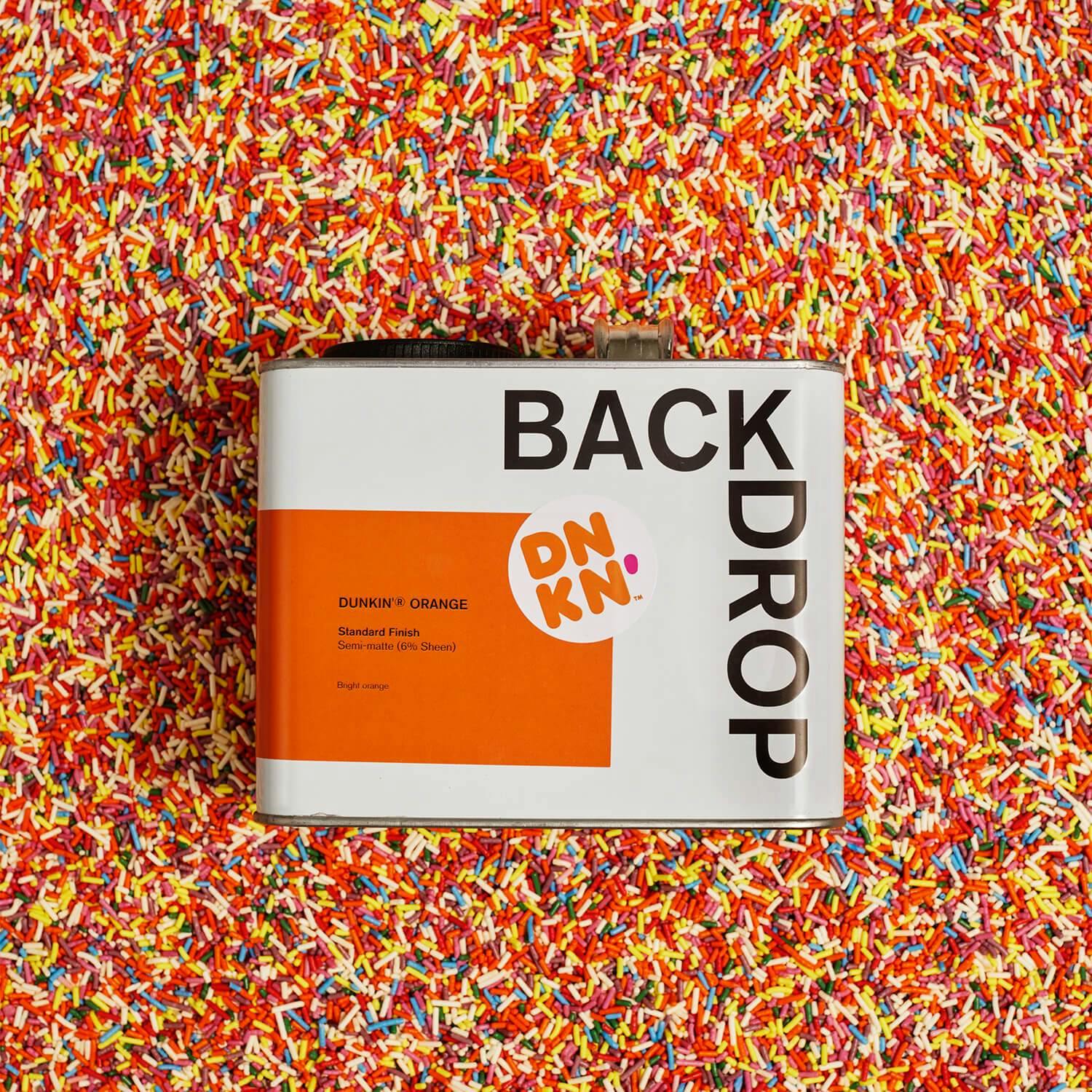 Dunkin'®  Orange paint can on a bed of colorful sprinkles