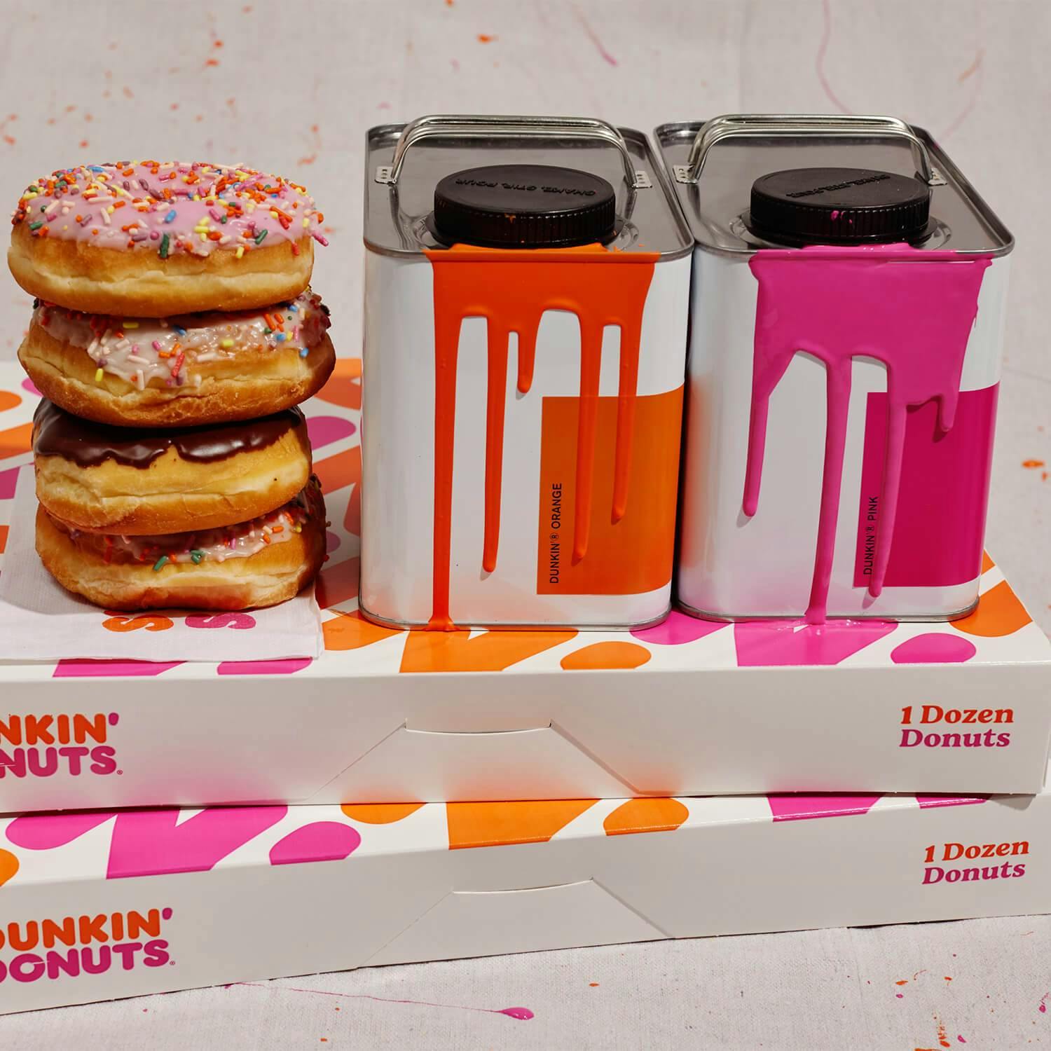 Paint cans next to a stack of donuts on top of two donut boxes
