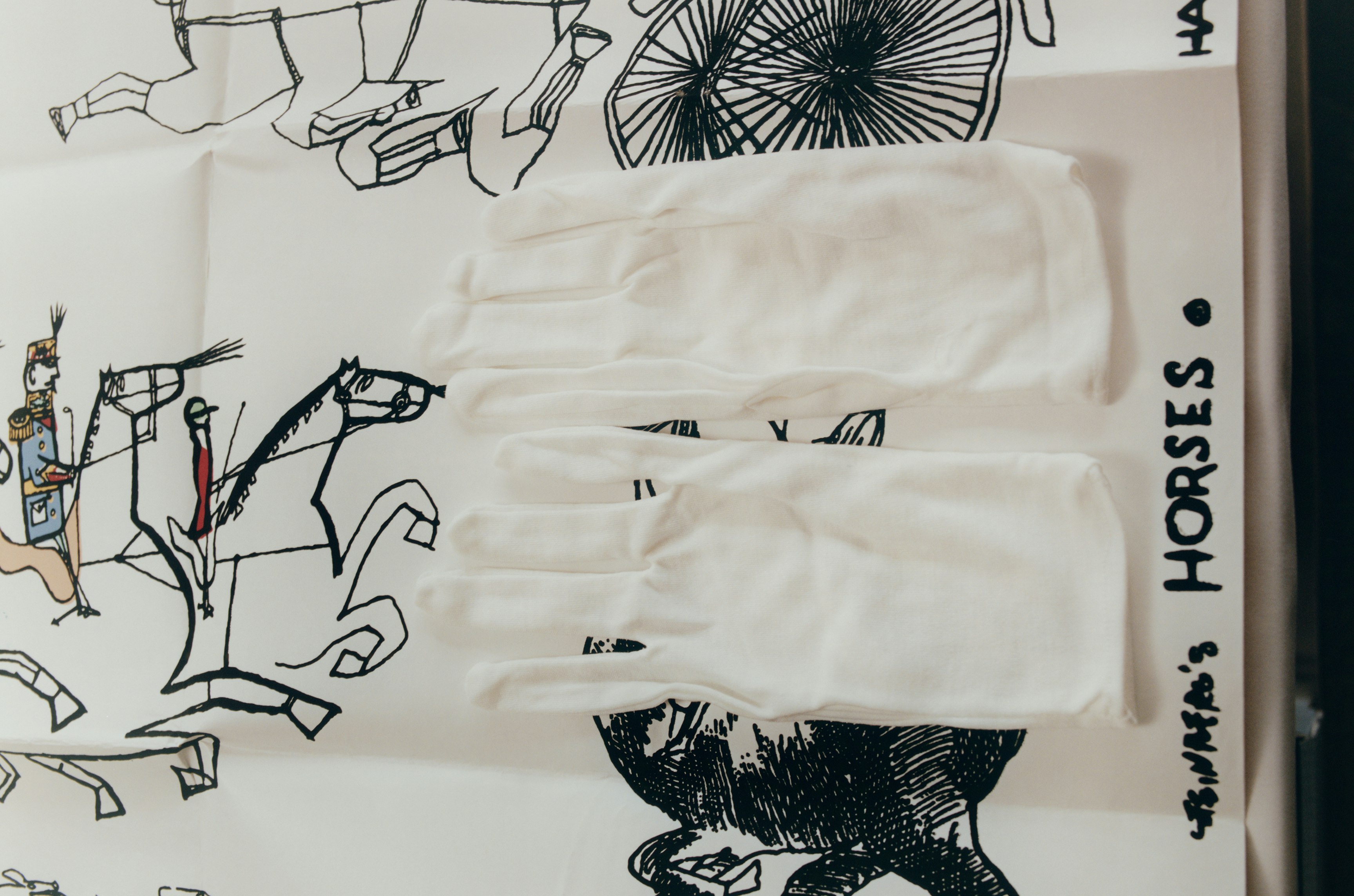 White archivist gloves lay on the original artwork for HORSES, a design by Saul Steinberg, reimagined by Backdrop for ARCHIVE by Backdrop